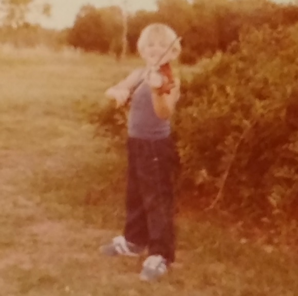 Bronius playing violin as a child